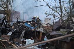 Des pompiers dégagent les débris de maisons dans la banlieue de Kharkiv, en Ukrainre, après l’attaque de drones russes, le 21 mai 2024.