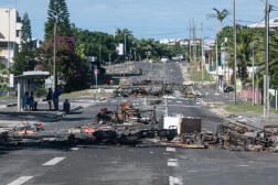 Une rue bloquée par des débris et des objets brûlés après les troubles de la nuit dans le quartier de Magenta à Nouméa, le 18 mai 2024.