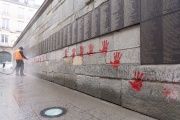 A municipal employee cleans the Mur des Justes covered in red-hand graffiti in front of the Shoah Memorial, Paris, May 14, 2024.
