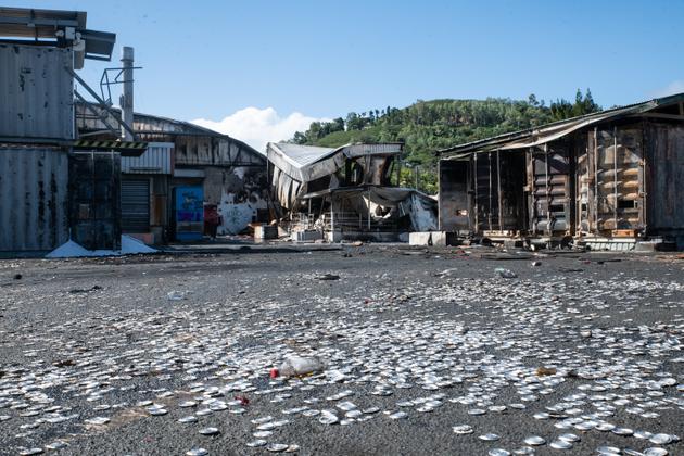 Can caps litter the parking lot of the burnt-out Le Froid beverage factory in the pro-independence district of Montravel, Nouméa, New Caledonia, May 23, 2024.