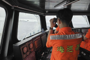 A Taiwanese coast guard member watches over a Chinese navy vessel operating near Pengjia islet, north of Taiwan, on May 23, 2024.