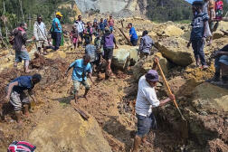 Villagers search through a landslide in Pogera village, in the Highlands of Papua New Guinea, Sunday, May 26, 2024.