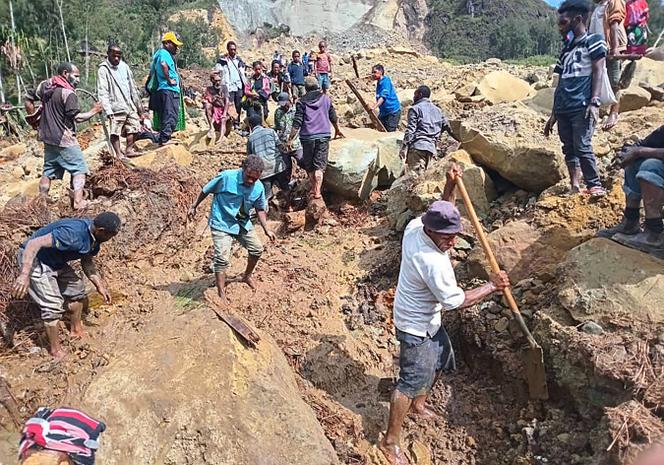 Questa foto scattata dall'Organizzazione internazionale per le migrazioni il 26 maggio 2024 mostra persone che scavano in un sito di frana nel villaggio di Yambali, nel distretto di Maipe Mulitaka, nella provincia di Inga, Papua Nuova Guinea. 