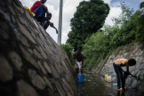 Des personnes récupèrent des eaux usées dans le quartier Cavani, à Mamoudzou (Mayotte), le 11 février 2024. 
