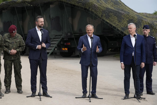El primer ministro polaco, Donald Tusk, en el centro, rodeado por el ministro de Defensa, Wladyslaw Kosiniak-Kamysz (izquierda) y su colega del Interior, Tomasz Siemoniak (derecha), en Dubicze Cerkiewne, en el este de Polonia, el 29 de mayo de 2024.