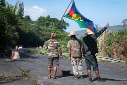 Un drapeau kanak brandi au milieu de la route au col de la Pirogue, à Païta, en Nouvelle-Calédonie, le 4 juin 2024.