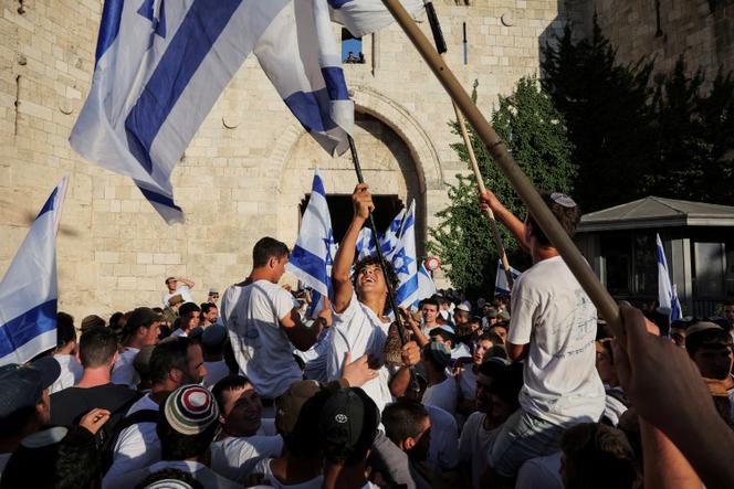 Israelis sit on the shoulders of other participants as they wave flags at the annual Jerusalem Day march, amid the ongoing conflict in Gaza between Israel and Hamas, at Damascus Gate in Jerusalem, June 5, 2024.