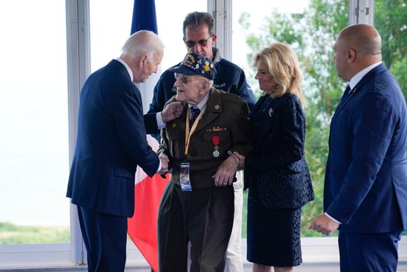 Le président américain, Joe Biden, et son épouse, Jill, saluent un vétéran de la seconde guerre mondiale au cimetière militaire de Colleville-sur-Mer, jeudi 6 juin 2024.