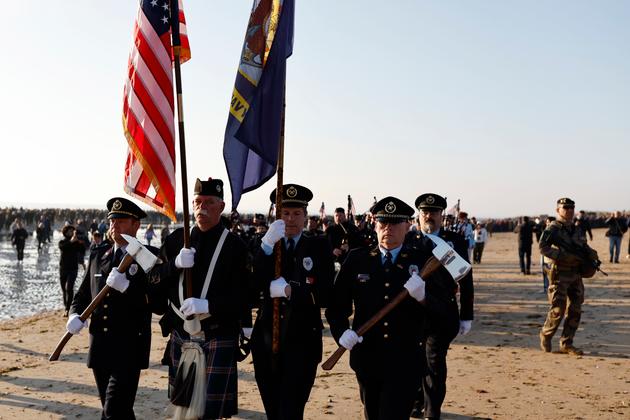 Participants march during a ceremony at Utah Beach near Saint-Martin-de-Vareville Normandy, Thursday, June 6, 2024. 