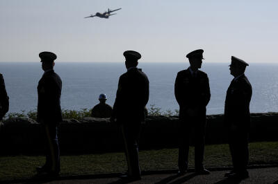 Des participants observent le passage d’un avion lors d’une cérémonie près de Colleville-sur-Mer, en Normandie, le jeudi 6 juin 2024. 