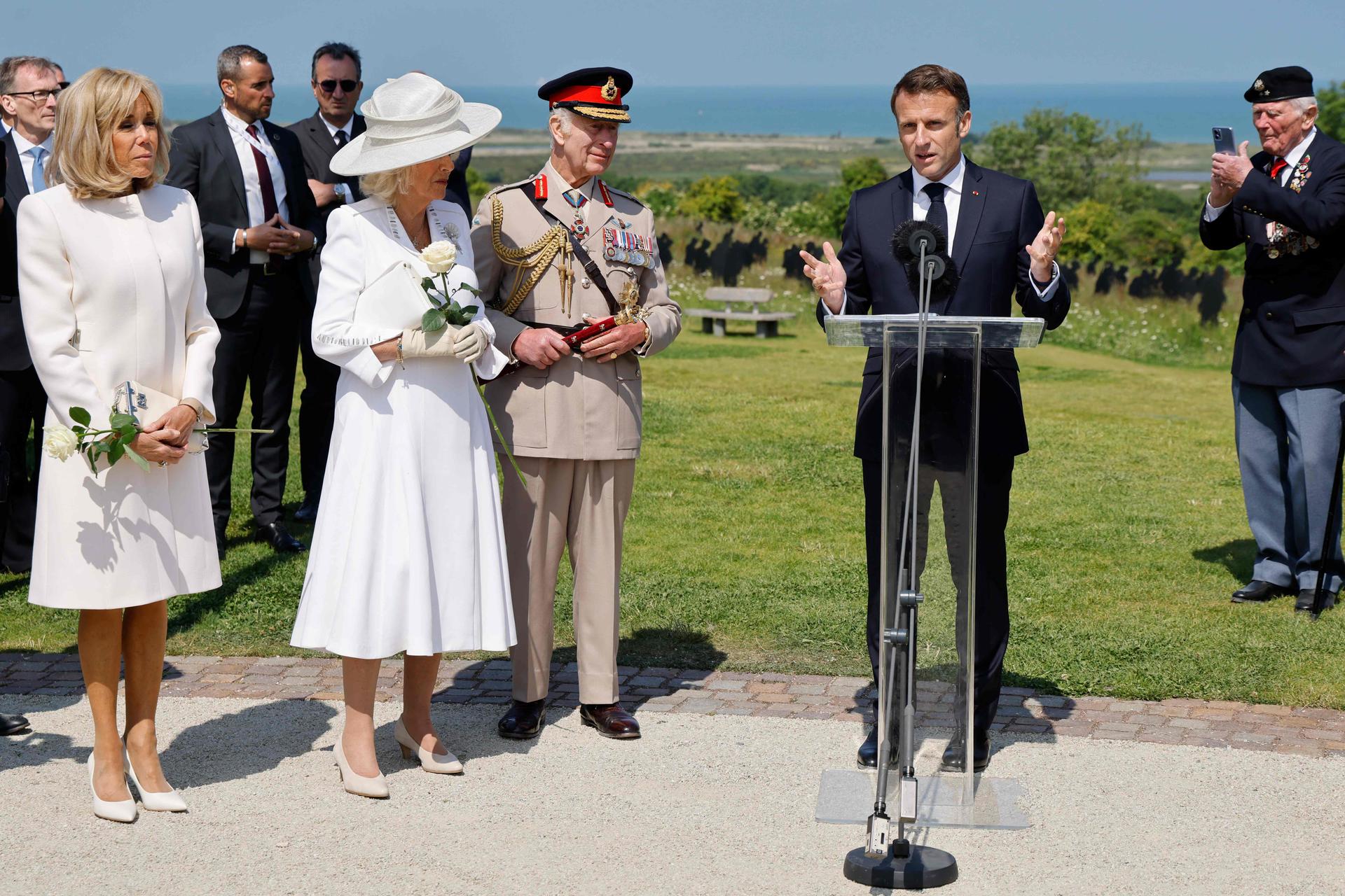 France's President Emmanuel Macron addresses British D-Day veterans as Brigitte Macron, Britain's Queen Camilla and Britain's King Charles III  look on at the World War II British Normandy Memorial near the village of Ver-sur-Mer which overlooks Gold Beach and Juno Beach in northwestern France, on June 6, 2024. 