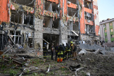 Des pompiers inspectent un immeuble de bureaux lourdement endommagé après une attaque aérienne russe à Kharkiv, le 25 mai 2024.
