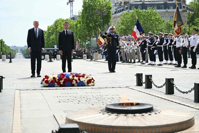 US President Joe Biden and France's President Emmanuel Macron stand in front of the Tomb of the Unknown Soldier as they participate in a ceremony as part of a state visit to France, at the Arc de Triomphe in Paris on June 8, 2024. 