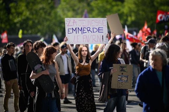 A protester holds a sign reading “Youth piss off the FN/RN” as thousands of people demonstrate against the National Rally in Rennes, June 11, 2024.