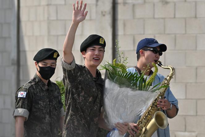 Jin, membre du boys band BTS, salue la foule à la fin de son service militaire obligatoire, aux côtés de ses collègues RM (à droite) et Jimin (à gauche), à l’extérieur d’une base militaire à Yeoncheon (Corée du Sud), le 12 juin 2024.