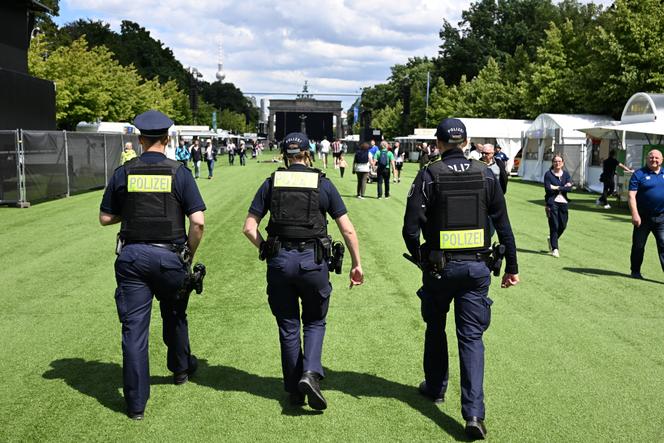Des policiers patrouillent sur le gazon artificiel installé pendant le championnat d’Europe des nations de football, devant la porte de Brandebourg, à Berlin, le 13 juin 2024.
