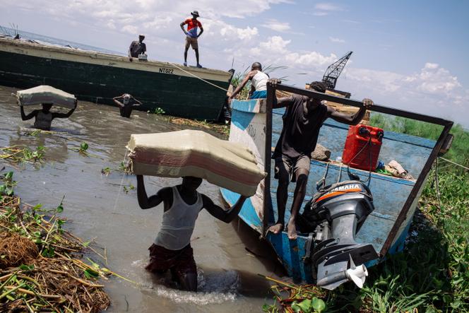 Des manutentionnaires déchargent des marchandises venues de l’Ouganda au port de Kasenyi, dans la province de l’Ituri (République démocratique du Congo), le 23 mai 2024. 