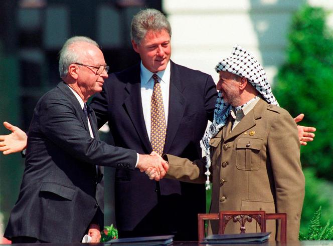Le président américain Bill Clinton, avec le premier ministre israélien Yitzhak Rabin (à gauche) et le chef de l’OLP, Yasser Arafat, le 13 septembre 1993, à la Maison Blanche, à Washington, pour une poignée de main historique scellant les accords de paix d’Oslo.
