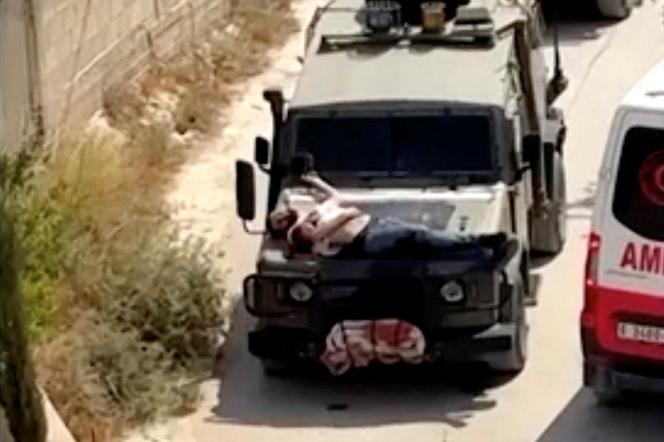 Un Palestinien blessé attaché sur le capot d’un véhicule militaire israélien, le 22 juin 2024 à Jénine, en Cisjordanie occupée.