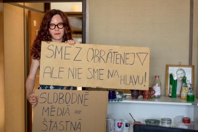 Novinárka Kristína Shrenková z RTVS drží nápisy: 