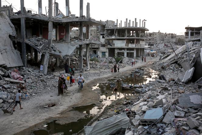 Displaced Palestinians in a street in Khan Yunis shelled by the Israeli army, where a trickle of sewage flows, in the Gaza Strip, July 4, 2024.