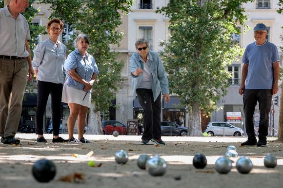 Claude (c), 80 ans, joue à la pétanque place Marécal-Lyautey dans le 6e arrondissement avec ses amis de l’association Accueil des villes de France, à Lyon, le 7 juillet 2024.
