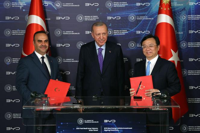 Le président turc, Recep Tayyip Erdogan (au centre), entouré du ministre turc de l’industrie et de la technologie, Mehmet Fatih Kacir, et du directeur général de BYD, Wang Chuanfu, à Istanbul, le 8 juillet 2024, lors de la cérémonie de signature d’un accord.