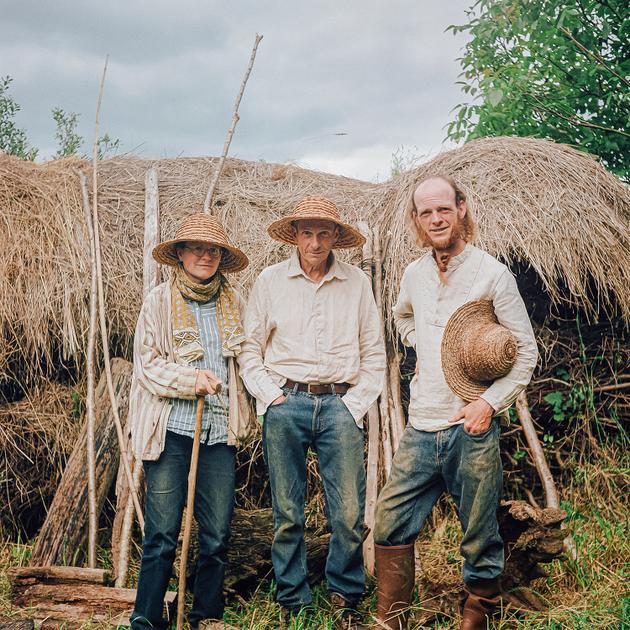 De gauche à droite, Bethan Lewis, son père, Gareth, et son frère, Samuel, devant l’une de leurs réserves de bois de chauffage protégées par de la paille de chaume, à Duault (Côtes-d’Armor), le 24 juin.