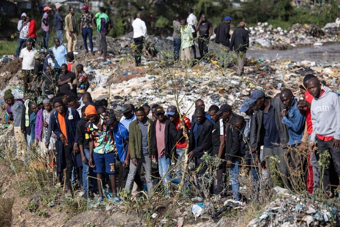 Passersby gather near a rubbish dump where six bodies were discovered in the Mukuru slum in Nairobi on July 12, 2024.