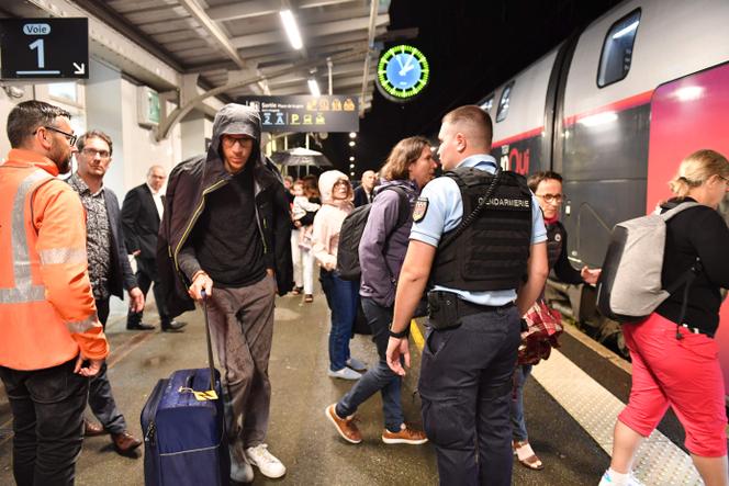 Des passagers montent à bord d'un train TGV Paris-Nantes immobilisé pendant plusieurs heures suite à une odeur suspecte, à Sablé-sur-Sarthe, le 12 juillet 2024.