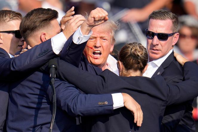Donald Trump is guarded by Secret Service agents after being the victim of an assassination attempt on July 13, 2024, in Butler, Pennsylvania.