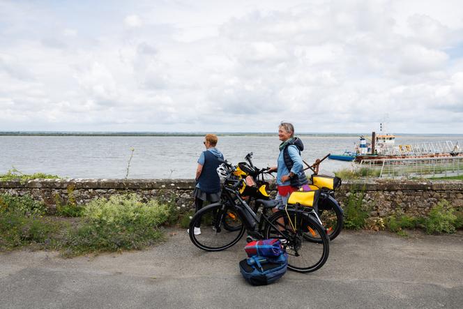 Deux touristes font une pause devant la Loire, à Paimbœuf (Loire-Atlantique), le 12 juillet 2024.