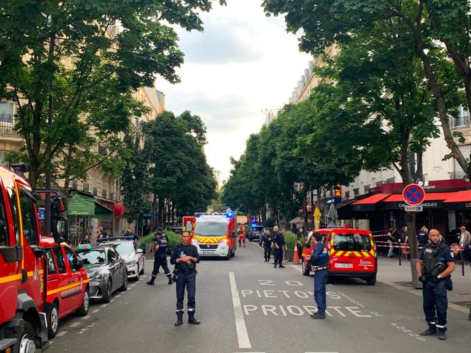 Des policiers français se tiennent à côté de véhicules de secours, près du café Le Ramus, à Paris, le 17 juillet 2024.