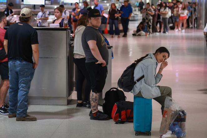 Des voyageurs font la queue pour vérifier auprès des représentants de la compagnie aérienne Delta où se trouvent leurs bagages à l’aéroport de Detroit Wayne County le 20 juillet 2024, à Detroit, dans le Michigan, aux Etats-Unis.