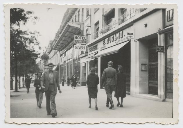 "Paris, Mr. Fritz on the boulevards, will he go to the hotel with the two chicks... Mystery?... View taken Sunday July 14, 1940, 2 pm", reads the back of the photograph.