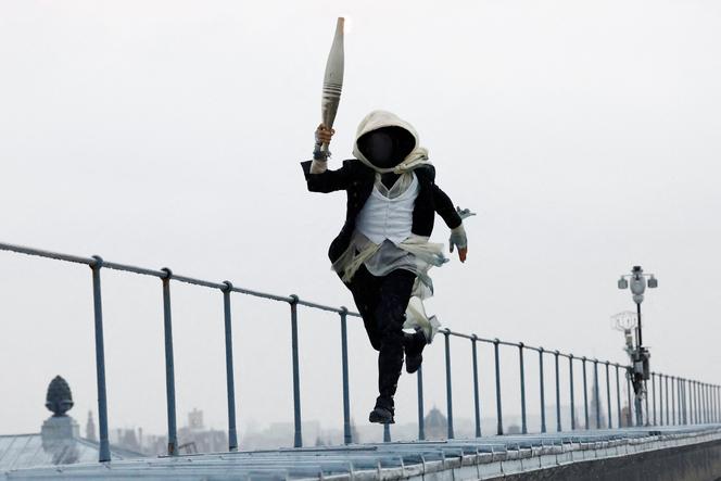 Heavy rain, Céline Dion, hooded torchbearer, diversity... The key moments of a memorable opening ceremony | WN24 5 A mysterious torchbearer runs atop the Musée d'Orsay during the opening ceremony, in Paris, on July 26, 2024.