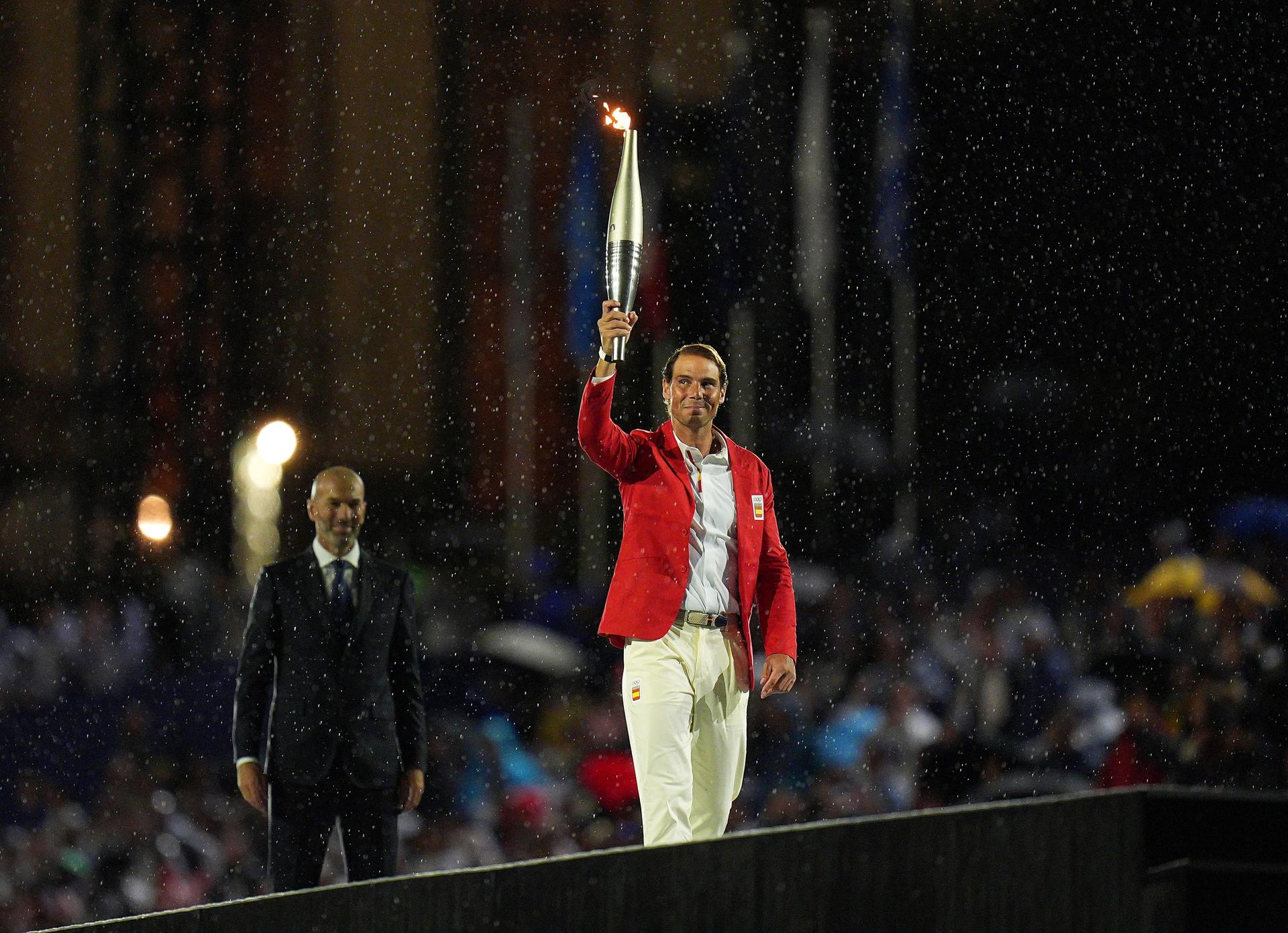 Zinedine Zidane geeft de Olympische fakkel door aan Rafael Nadal tijdens de openingsceremonie van de Olympische Spelen op 26 juli 2024.