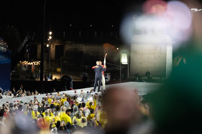 Cérémonie d'ouverture des jeux olympiques, le 26 juillet 2024, à Paris, au Trocadéro. Zinédine Zidane entre sur scène pour porter la flamme olympique. Il la transmet à Raphael Nadal.