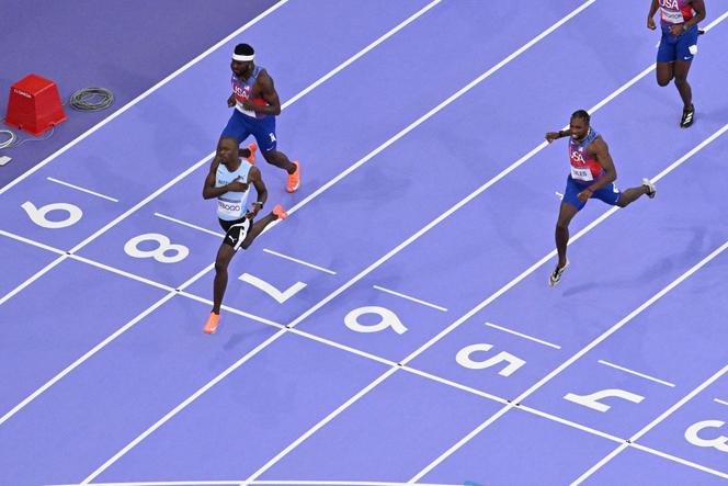 Le Botswanais Letsile Tebogo franchit la ligne d'arrivée devant les Américains Noah Lyles et Kenneth Bednarek lors de la finale du 200 m masculin aux Jeux de Paris 2024 au Stade de France à Saint-Denis le 8 août 2024. 