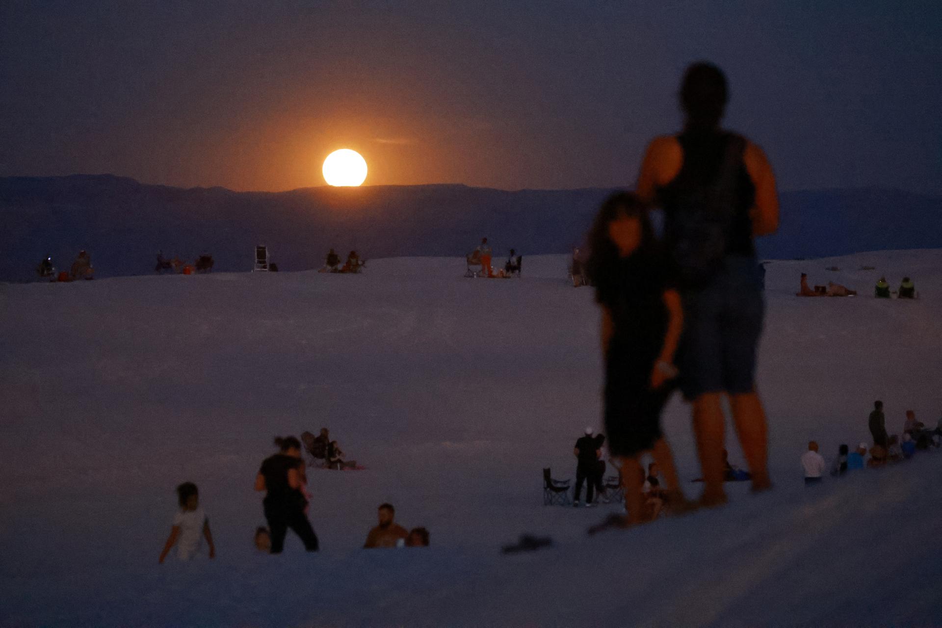 Le persone si riuniscono per vedere la superluna al White Sands National Park vicino ad Alamogordo, New Mexico, Stati Uniti, 19 agosto 2024.