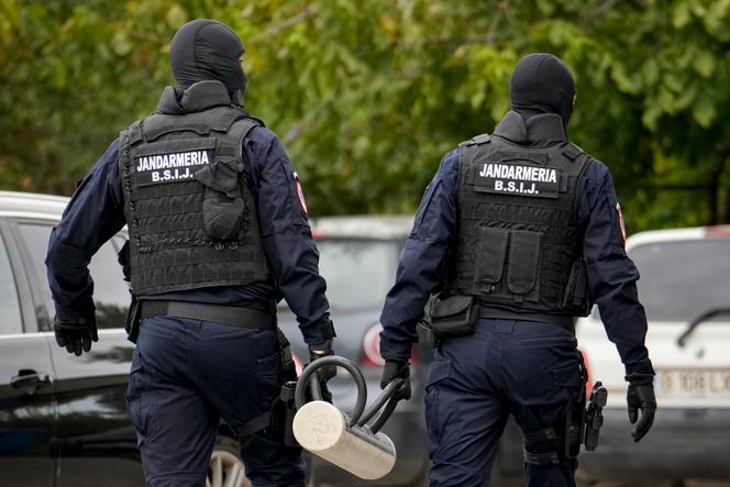 Des gendarmes tiennent un bélier utilisé pour enfoncer une porte à l’extérieur de la résidence de l’influenceur Internet Andrew Tate lors d’une perquisition matinale de la police, dans la banlieue de Bucarest, en Roumanie, le mercredi 21 août 2024.
