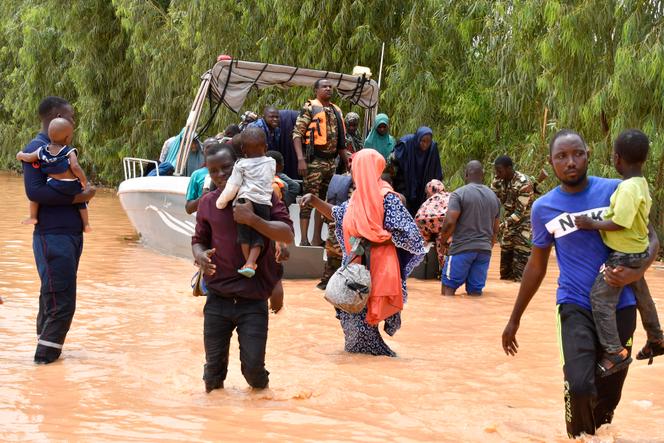 Police boats evacuate people after heavy rain damaged National Road 25, which links the Nigerian capital Niamey with Tillaberi and Dahua provinces in western Niger, on August 20, 2024. 