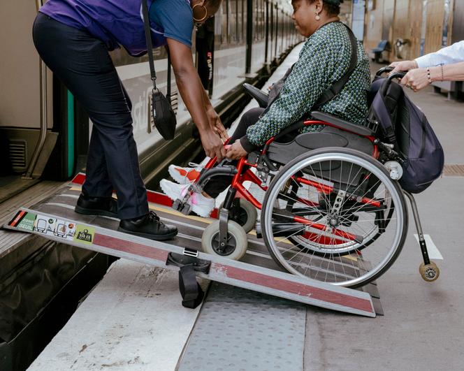 Le métro parisien n’étant quasi pas accessible aux fauteuils roulants, Ndieme Lame, bénévole pour les Jeux olympiques et paralympiques, doit emprunter le RER B avec l’assistance d’un agent (ici, le 21 août 2024).