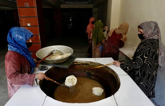 Des Afghanes font frire de traditionnels gâteaux dans une boulangerie de Kaboul, le 5 mai 2024.