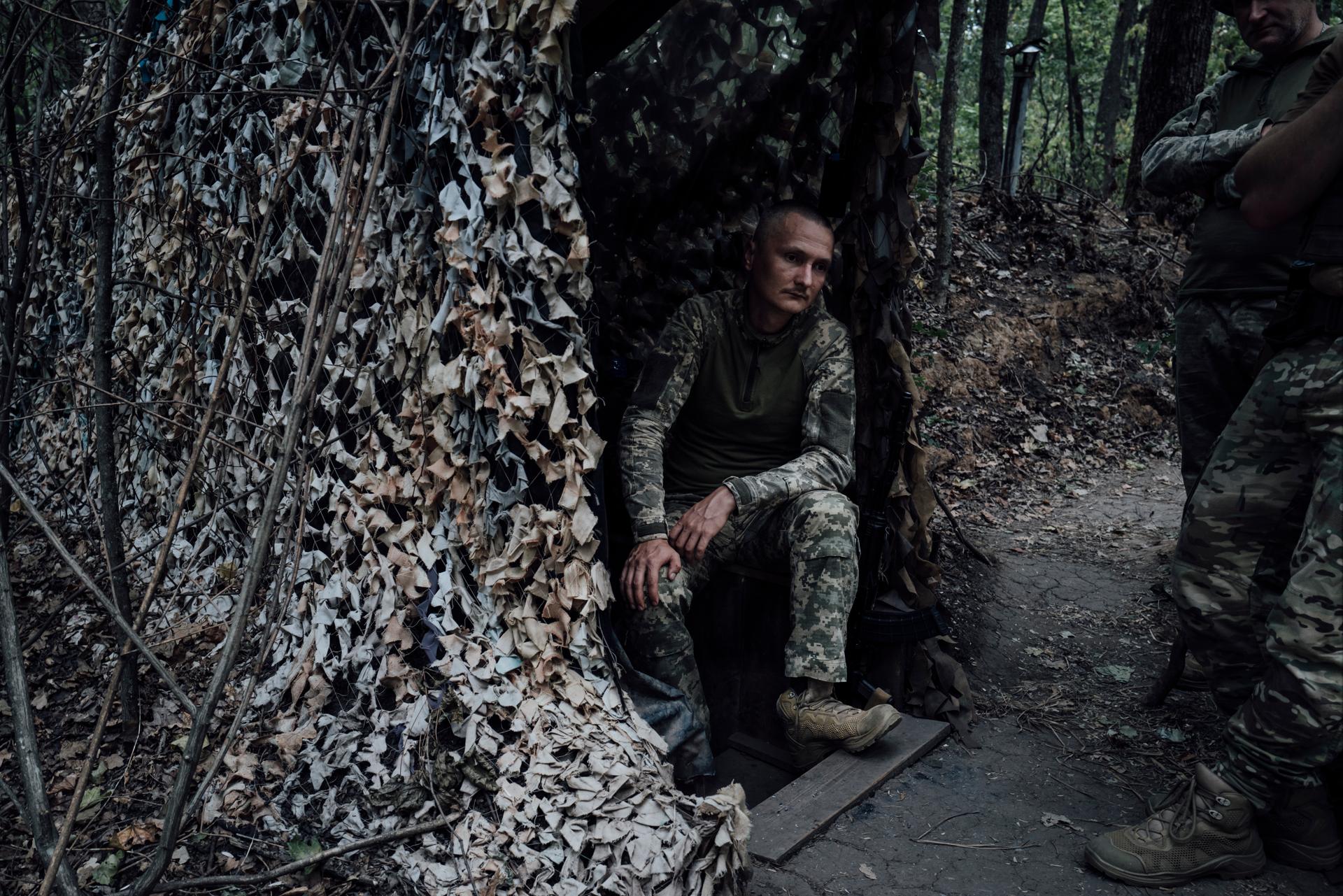 A soldier from Ukraine's 117th Territorial Defense Brigade waits for firing orders at the entrance to a shelter in the Sumy region, August 23, 2024.