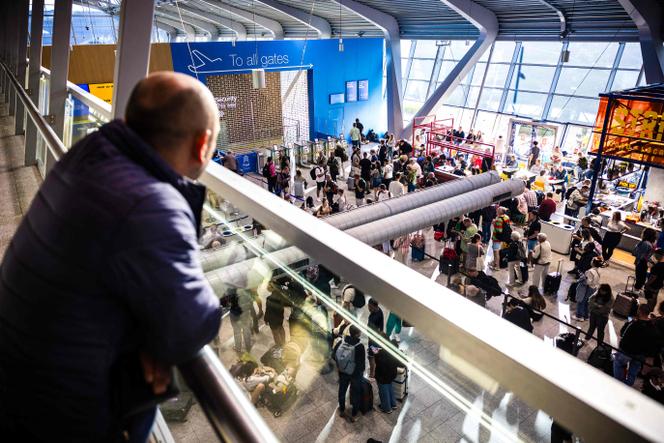 Des voyageurs patientent à l’aéroport d’Eindhoven, alors qu’une panne informatique a touché l’aéroport régional et plusieurs services publics dont les garde-côtes et la police militaire aux Pays-Bas, à Eindhoven le 28 août 2024.