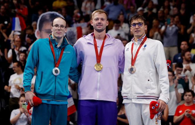 Le Biélorusse Ihar Boki sur le podium après sa victoire sur 100 m dos (S13), le 30 août, à Paris La Défense Arena, aux côtés du Russe Vladimir Sotnikov (à gauche) et du Français Alex Portal (médaillé de bronze). 