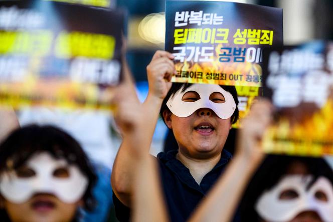 Des activistes portant des masques pour les yeux tiennent des affiches sur lesquelles on peut lire « Crimes sexuels répétés, l’Etat est aussi complice », lors d’une manifestation contre le deepfake pornographique à Séoul, le 30 août 2024.