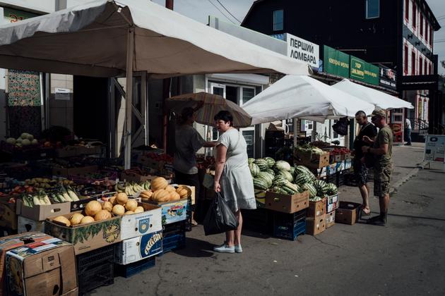 Civilians and military personnel cross paths on the Pokrovsk market in Ukraine, September 1, 2024.