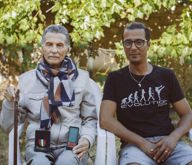 Messaoud, ancien chef de secteur du FLN, présente ses deux médailles, une francaise et une algérienne, accompagné de son fils Karim, à Orléans, en août 2022.
